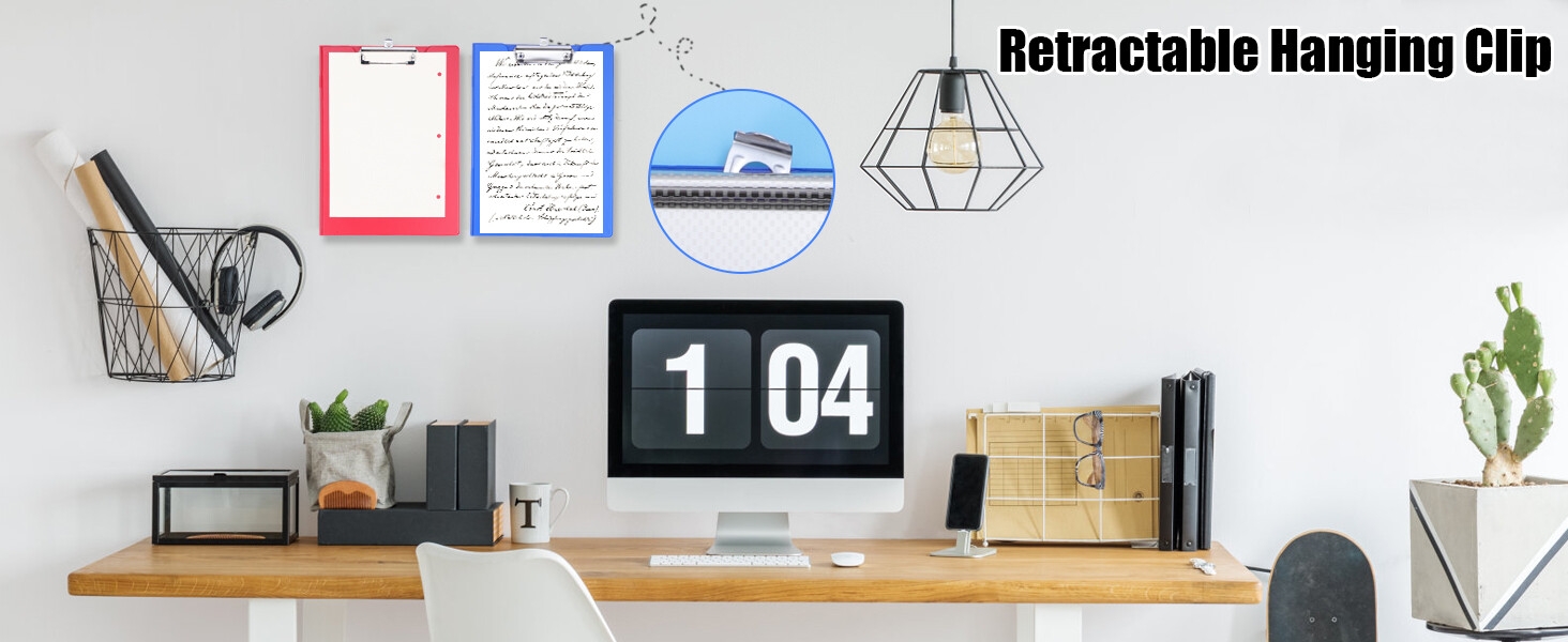 Modern workspace setup with wooden desk, digital clock display, and retractable hanging clip system on white wall with decorative items.