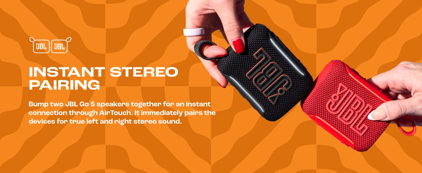 Text reads 'INSTANT STEREO PAIRING'. Orange background with two red and black wireless speaker devices held in hands, demonstrating pairing capability and product design.