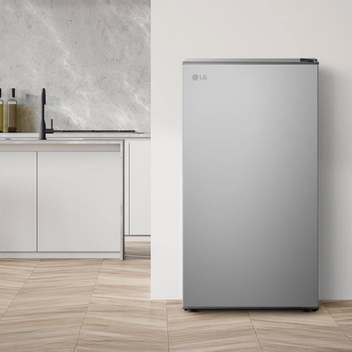 Modern kitchen interior with a 1Door refrigerator placed beside a wooden panel wall and minimalist cabinetry