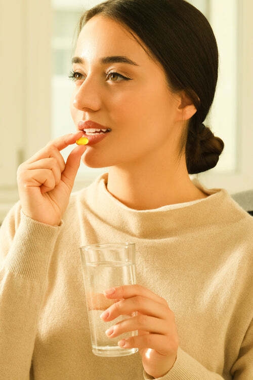 image of a lady taking a clear supliment