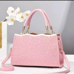 Pink handbag features a signature embossed pattern 